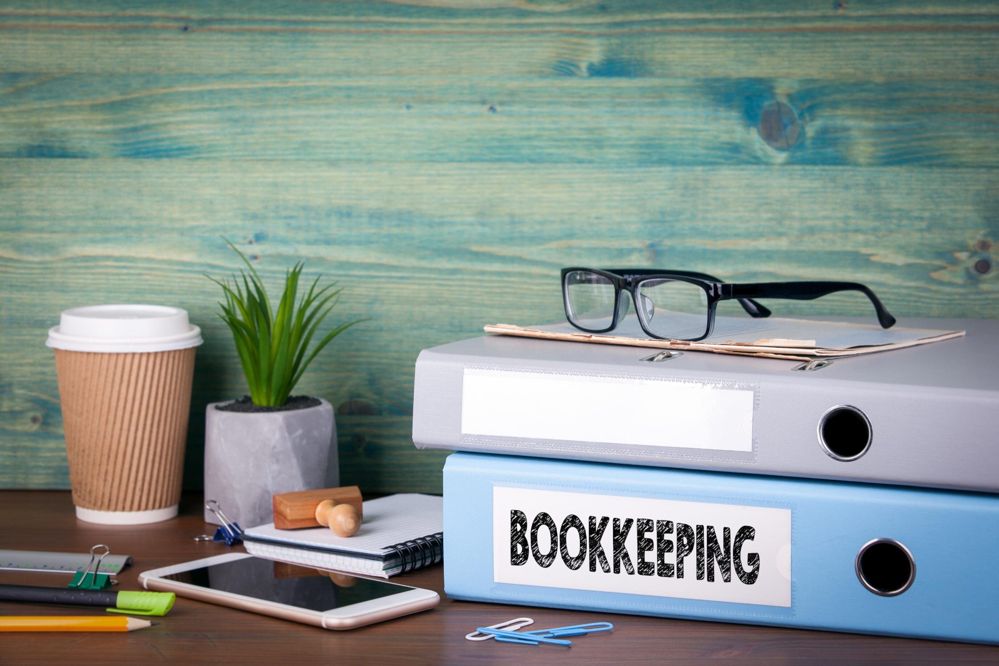 A tidy workspace with bookkeeping files and glasses.